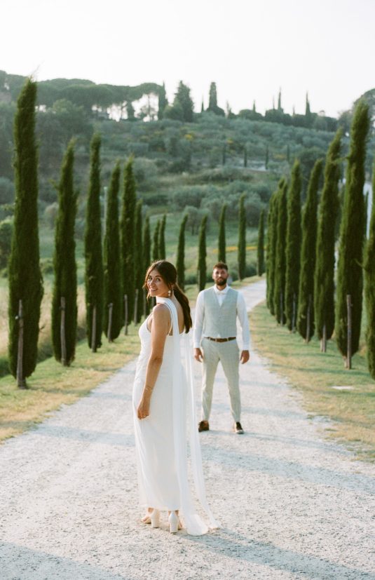 Bride and groom on a cypress-lined path